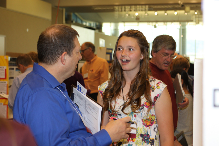 Photo from a previous Colorado Science Fair showing an excited student speaking to a judge.